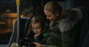 unge med mor använder sig av mobiltelefon i de buss video
