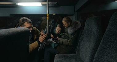 Mom, dad and son traveling bus in the evening and using cellphones video