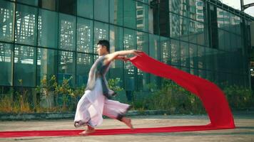 an Asian man is waving a red cloth with his hand while in an old building video