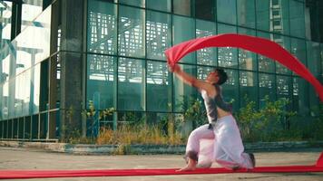 een Aziatisch Mens is golvend een rood kleding met zijn hand- terwijl in een oud gebouw video