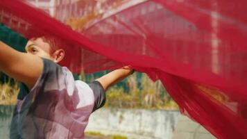 an Asian man runs with a red cloth and waves it behind him very cheerfully when the wind is blowing video