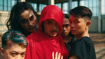un grupo de asiático hombres posando con enojado caras como su amigos vestir rojo batas en un antiguo edificio video