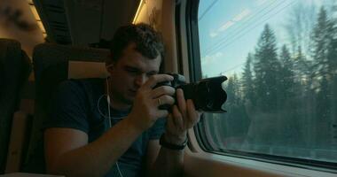 Man stocker in train listening to music and making footage video