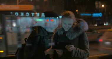 Young women with touch pad in evening city video