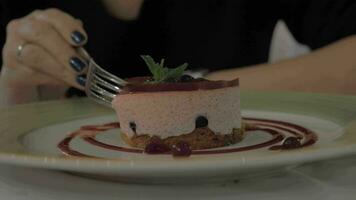 Woman eating mousse dessert with berries in restaurant video