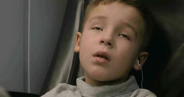 Boy watching TV in train, he listening audio with earphones video