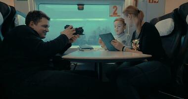 Shooting video of mom and child using pad during train ride