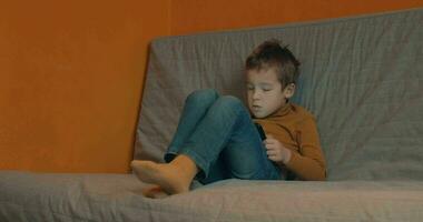 Child relaxing with tablet computer at home video