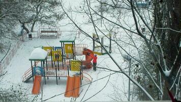 Mom and kid having fun on playground in winter video