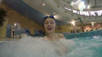 Joyful kid enjoying hydromassage in the pool video