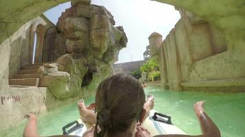 Child with mother getting excited with lazy river ride in water park video