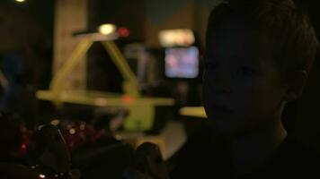 Close up view of small boy are playing video arcade game in game center