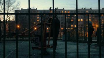 Children on the sports ground near the house in late evening video