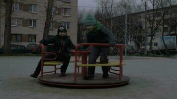 Children having fun on merry-go-round in the yard video