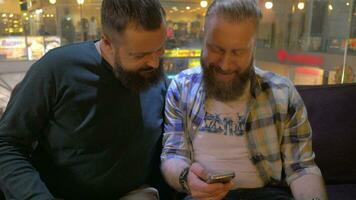 proche en haut vue de deux blanc mature barbu Hommes en utilisant téléphone intelligent ensemble video