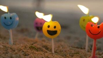 Colorful smiley candles on the beach video