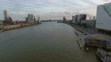 aereo Visualizza di paesaggio urbano con moderno edifici su il fiume contro nuvoloso cielo, Rotterdam, Olanda video