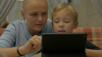Child and mom with digital tablet in cafe video