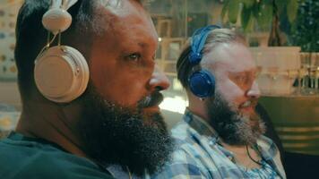 Bearded men in headphones enjoying music video
