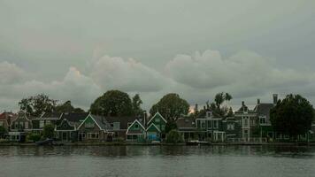 timelapse van wolken over- huizen Aan rivier- bank, Nederland video