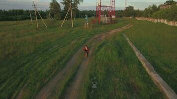 Teenager riding bike in the country, aerial view video