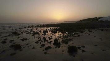 aéreo Visão do pedras em a costa e oceano às pôr do sol video