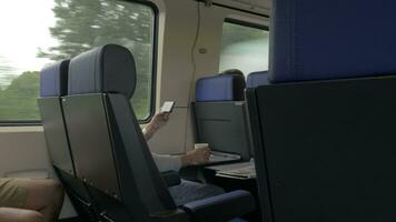 View of men in the train and working with laptop on the table and drinking against window, Netherlands video