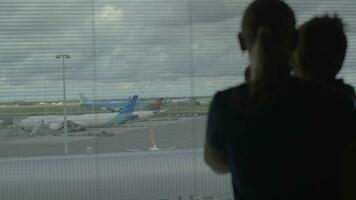 Mutter und Sohn suchen durch Flughafen Fenster video