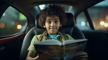 Little boy reading a magazine in a car photo