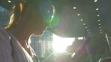 Frau mit Zelle im Stadt gegen hell Sonnenschein video