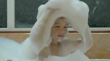 Child having fun with foam in the bath video