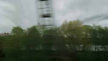 View from riding train window of coutryside landscape, trees, forests, houses against cloudy sky video