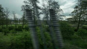 Timelapse view from riding train window of coutryside landscape, trees, forests, houses against cloudy sky video