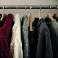 Warm knitted clothes hanging on a rack. AI Generative photo