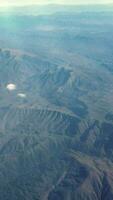 vertical vídeo vôo sobre montanhas panorama com uma Claro azul céu. video