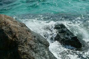 hermosa escénico marina azul Oceano mar agua en rock costa playa con chapoteo ola en isla, cielo verano Roca acantilado costero marea antecedentes para viaje y turismo, alto poder turquesa Pacífico foto