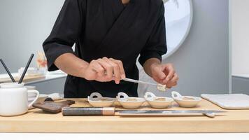 Professional chef preparing and cooking raw fresh fish ingredient on the table with knife for delicious sushi and sashimi meal, Person making luxury omakase fine dining Japanese food restaurant dinner photo