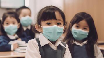 a group of children wearing a face mask sitting in chairs in a classroom photo