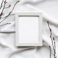 Mockup blank photo frame and branches on white cotton fabric top and vertical view. AI Generative