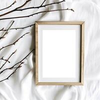 Mockup blank photo frame and branches on white cotton fabric top and vertical view. AI Generative