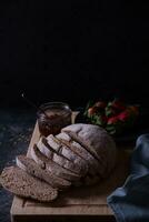 Freshly prepared and sliced bread served on the table with jam and strawberries. photo