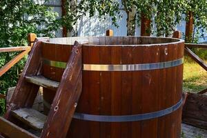 wooden barrel with ladder for swimming after bath. photo