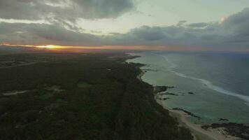 volador a lo largo el línea costera de Mauricio a puesta de sol video
