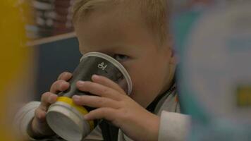 View of small boy drinking from the paper cup and smiling, fast food cafe video