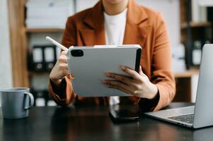 Bussinessman analyzing sales data and economic growth and pointing at business report document with graph chart financial chart marketing, banking and payments at modern office photo