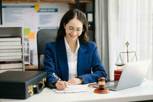 hermosa mujer abogado trabajando y mazo, tableta, ordenador portátil en frente, Consejo justicia y ley concepto. foto