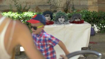 Child and funny heads on table in the street video