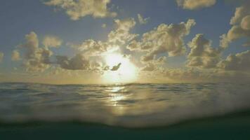 acenando mar água e pôr do sol dentro nublado céu video