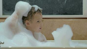 Child playing with foam in the bath video