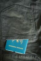 An Indonesian citizenship passport in a green denim pocket. photo